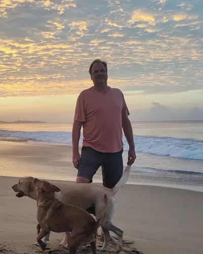 Alexander Horn, anfitrión de Rincón del Mar, en la playa de Pie de la Cuesta con sus perros